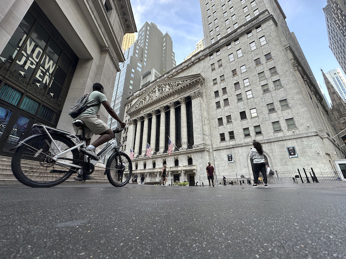 Un ciclista se acerca a la parte posterior de la Bolsa de Nueva York, el martes 9 de julio de 2024, en Nueva York.