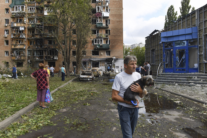 Vecinos de un edificio de apartamentos dañado tras proyectiles ucranianos abandonan la zona en Kursk, Rusia, el domingo 11 de agosto de 2024.