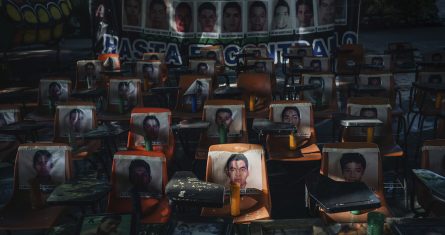 Fotos de los 43 estudiantes desaparecidos desde hace 10 años cubren unas escaleras en la escuela Normal Rural de Ayotzinapa.