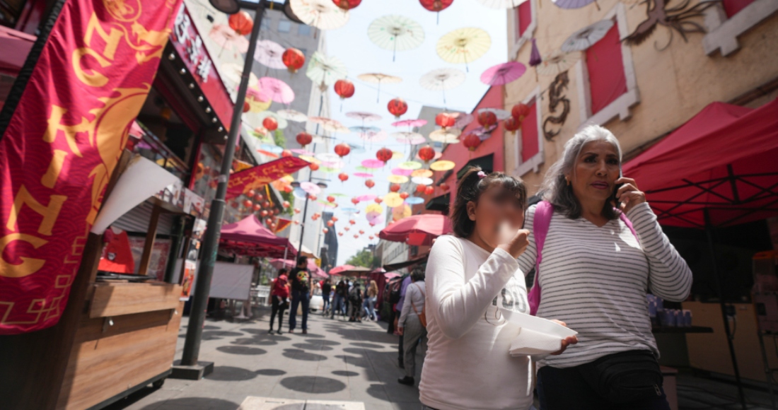 Turistas caminan bajo las sombrillas y lámparas en el Barrio Chino, el sábado 8 de junio de 2024, en el Centro Histórico de Ciudad de México. 