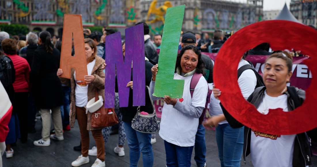 Simpatizantes del presidente mexicano Andrés Manuel López Obrador sostienen sus iniciales frente al Palacio Nacional donde realiza su última conferencia de prensa matutina en la Ciudad de México, el lunes 30 de septiembre de 2024. 