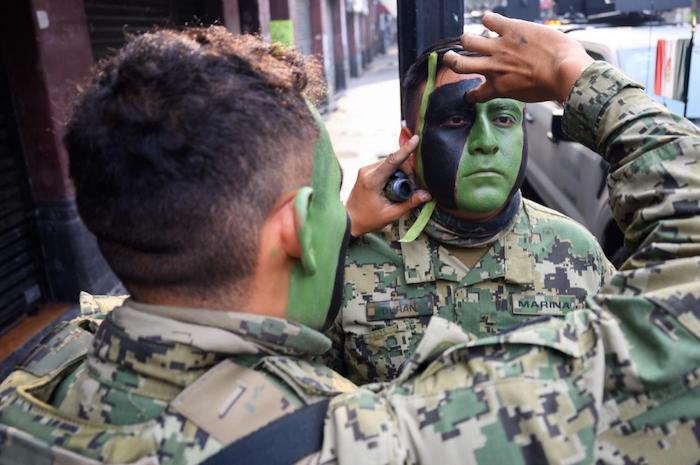 Elementos de la Marina se pintan el rostro antes de participar en el Desfile Cívico Militar.