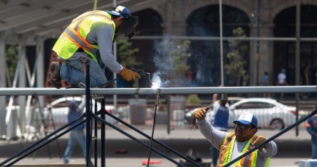 Trabajadores soldán un escenario que esta siendo colocado en el zócalo.