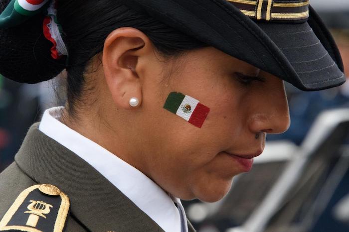 Una mujer que participó en el Desfile Militar luce una Bandera de México en sus mejillas.