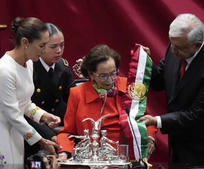 El Presidente saliente Andrés Manuel López Obrador entrega la banda presidencial a Ifigenia Martínez, presidenta de la Cámara de Diputados, en la ceremonia de toma de posesión de Claudia Sheinbaum, a la izquierda, en el Congreso en Ciudad de México, el martes 1 de octubre de 2024.