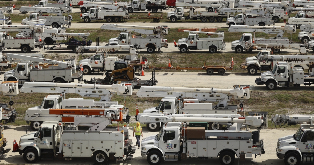 El director de proyecto de Duke Energy Tiger Yates, abajo en el centro, camina entre los cientos de camiones para reparaciones eléctricas el 8 de octubre de 2024 en The Villages, Florida, antes del huracán "Milton". 