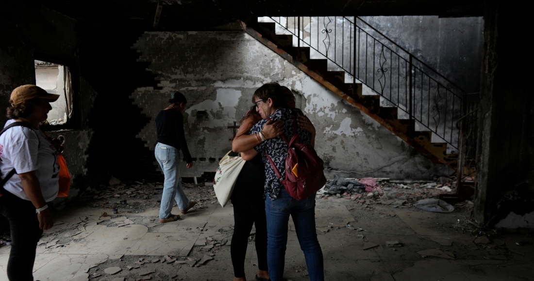 Gente abrazada en la casa de Maayan y Yuval Bar, asesinados por Hamás, en el primer aniversario del ataque de Hamás a Israel, en el kibutz Be'eri, una granja comunal israelí en la frontera con Gaza, el lunes 7 de octubre de 2024. 