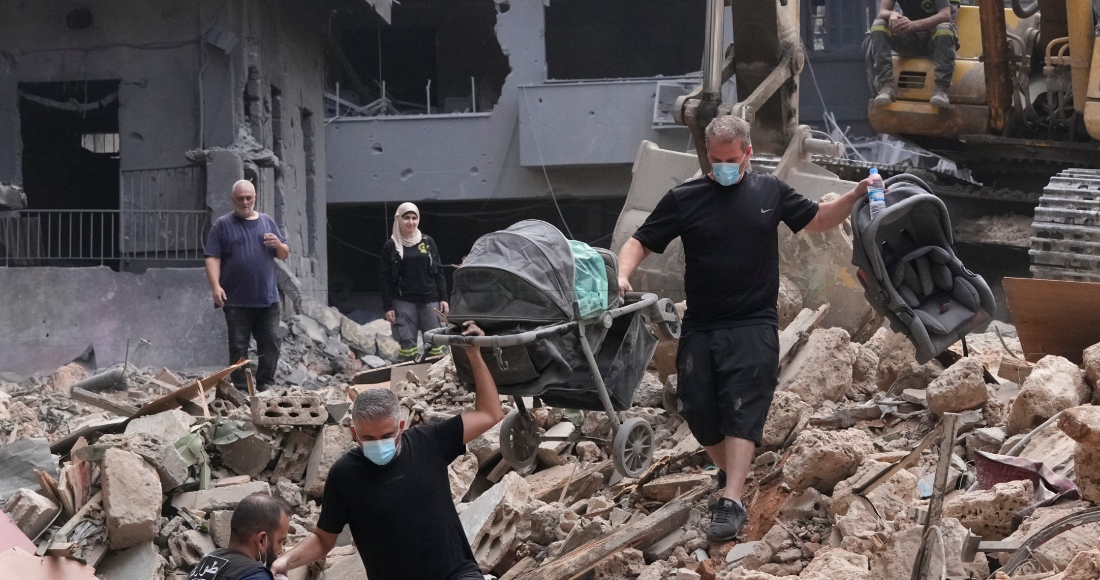 Vecinos de un edificio dañado por un ataque aéreo israelí regresan para recuperar las pertenencias de una familia en Beirut, Líbano, el sábado 12 de octubre de 2024.