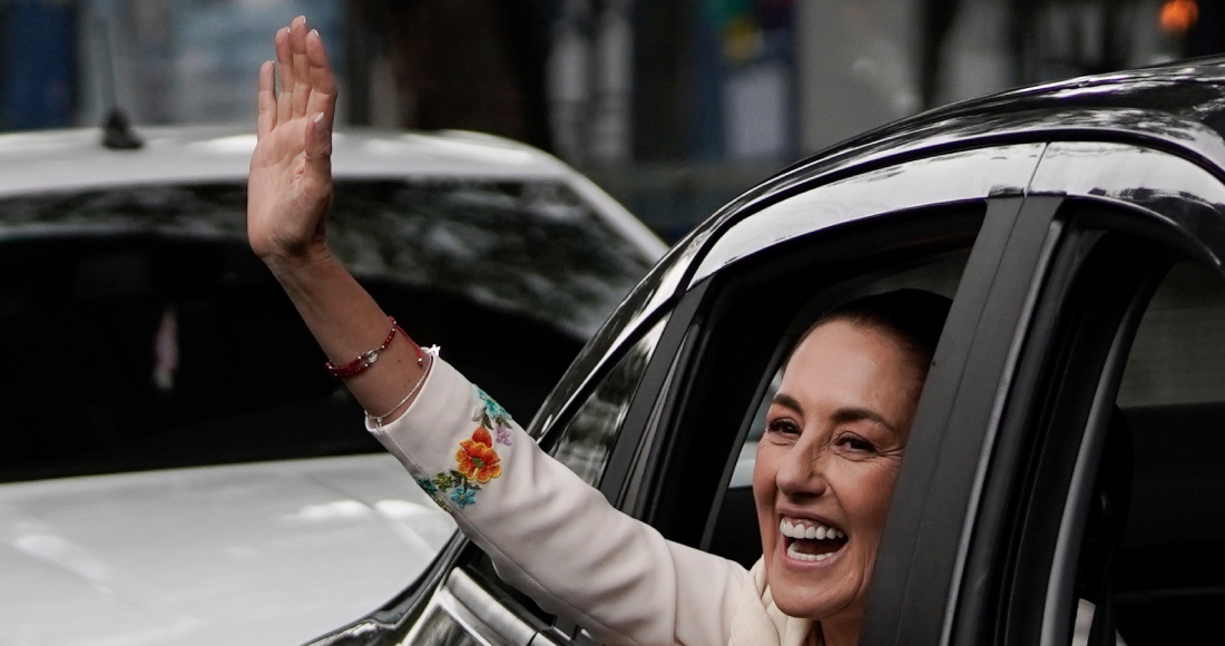 Claudia Sheinbaum saluda desde el vehículo que la lleva al Congreso donde prestará juramento como presidenta en la Ciudad de México, el martes 1 de octubre de 2024.