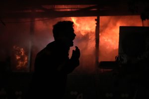 Un hombre grita frente a un incendio tras un ataque israelí