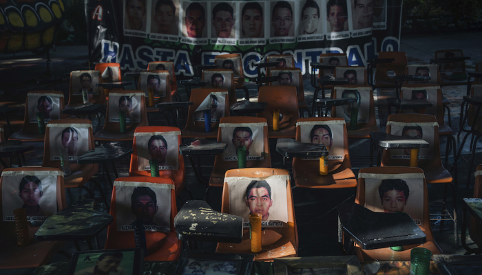 Fotos de los 43 estudiantes desaparecidos desde hace 10 años cubren unas escaleras en la escuela Normal Rural de Ayotzinapa.