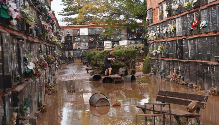 Un hombre camina por un cementerio inundado en las afueras de Valencia, España, el viernes 1 de noviembre de 2024, tras inundaciones en la región. 