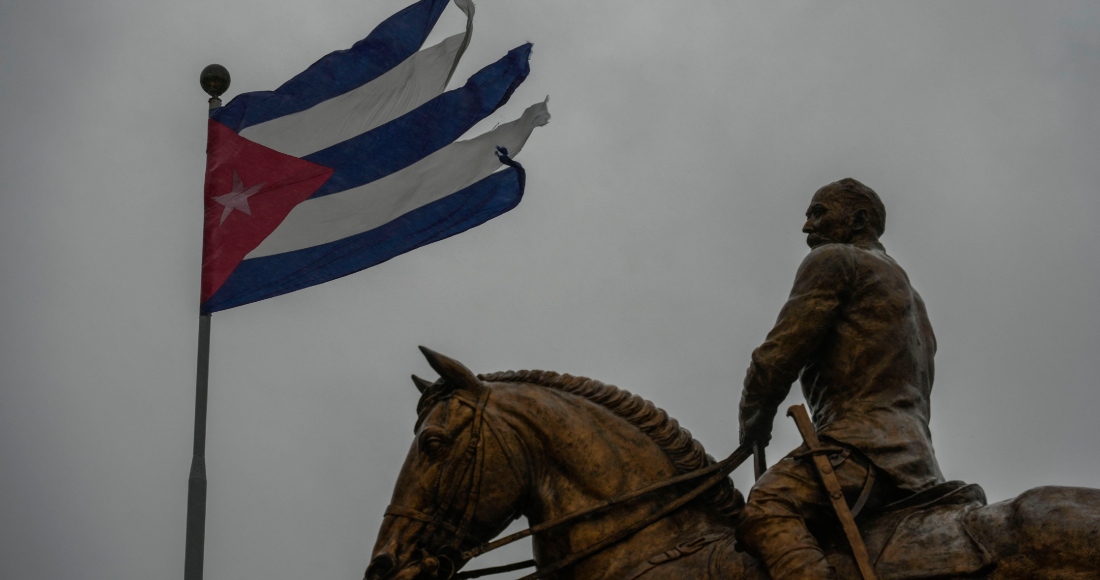 Una bandera de Cuba ondea bajo un cielo nubaldo