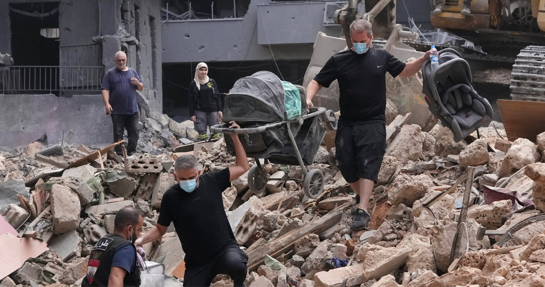 Residentes de un edificio dañado por un ataque aéreo israelí vuelven para recoger las pertenencias de su familia.