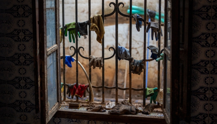 Guantes y utensilios de limpieza cuelgan en una ventana durante las labores de limpieza tras el paso de las inundaciones