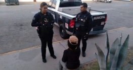 La mujer está espaldas a la cámara mientras habla con dos agentes de la policía; ella habría permanecido encerrada tres años por su pareja, hasta que pudo escapar.