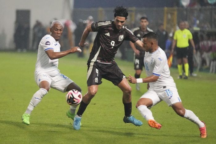 El delantero mexicano Raúl Jiménez, centro, y los hondureños Denil Maldonado, izquierda, y Edwin Rodríguez pelean por la pelota durante el partido por la Liga de Naciones de la Concacaf en el estadio Francisco Morazán en San Pedro Sula, Honduras. 