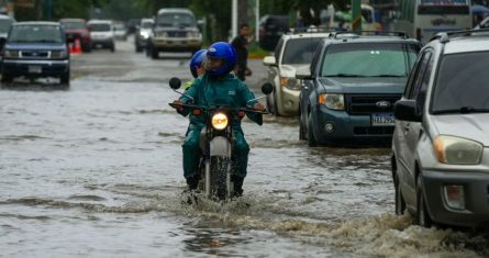 personas-a-bordo-de-una-motocicleta-en-calles-inundadas-de-honduras