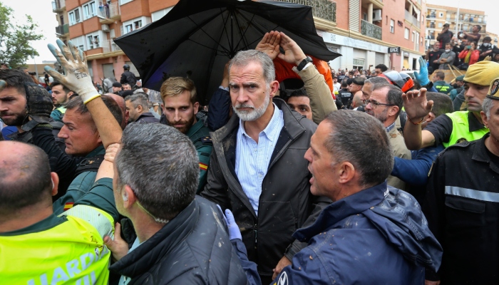 El rey Felipe VI es protegido por elementos de seguridad después de que una multitud enardecida arrojó lodo e insultó al monarca y a otros funcionarios gubernamentales cuando hicieron su primera visita a una de las poblaciones más afectadas por inundaciones, el domingo 3 de noviembre de 2024, en Paiporta, cerca de Valencia, España. 