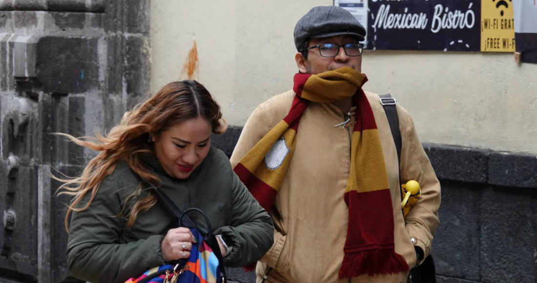 Transeúntes se cubren de la temperatura que se presenta en 16°C en la capital. Se prevé cielo medio nublado a nublado y condiciones limitadas para lluvia .