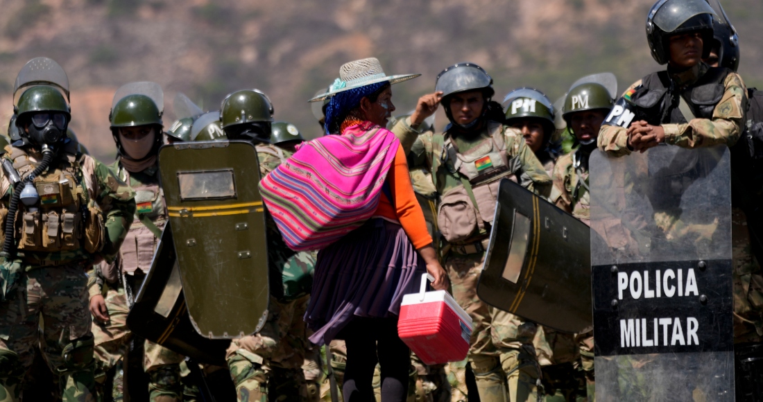 Una vendedora ofrece helados a la policía militar después de que retiraron los controles de carretera instalados por partidarios del expresidente Evo Morales para evitar que enfrente una investigación penal por acusaciones de abuso de una menor mientras estaba en el cargo, en Parotani, Bolivia, el viernes 1 de noviembre de 2024.