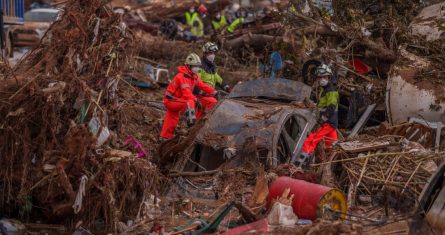 Rescatistas retiran automóviles en un área afectada por inundaciones.