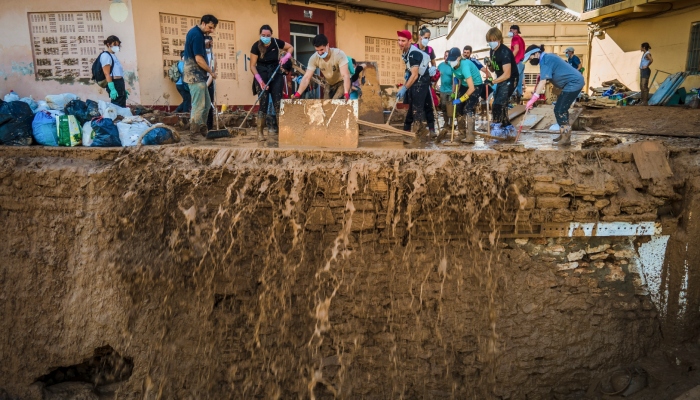 Varias personas retiran lodo de una calle en un área afectada por inundaciones, el lunes 4 de noviembre de 2024, en Catarroja, España. 