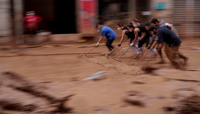 Varias personas retiran lodo de una calle en un área afectada por inundaciones, el lunes 4 de noviembre de 2024, en Catarroja, España. 