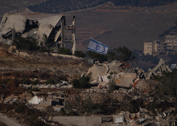 La bandera de Israel entre ruinas por la guerra.