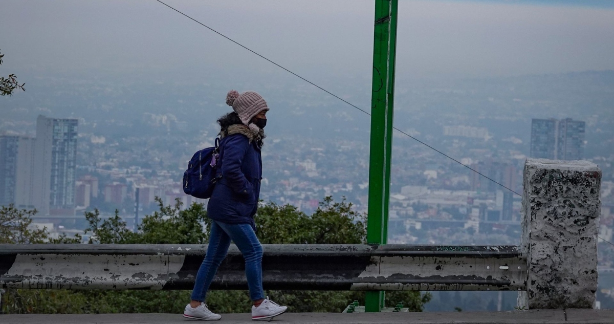 En imagen, una mujer se abriga para mitigar el frio de las primeras horas del día en la Ciudad de México.