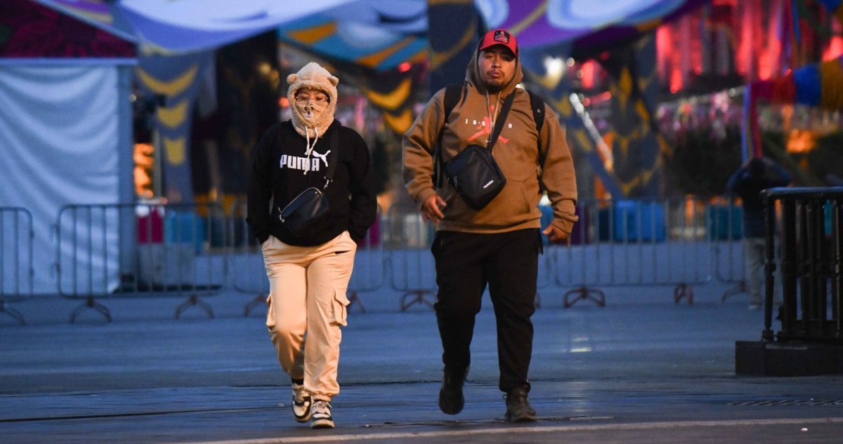 Las personas se protegen de las bajas temperaturas que se registran por las mañanas en la Ciudad de México.