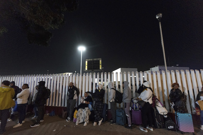 Migrantes de Cuba y Venezuela hacen fila en un puesto de control mexicano.