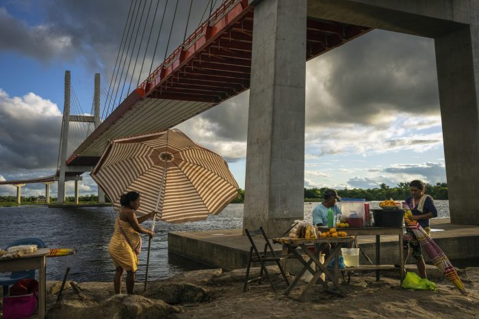 Unos vendedores colocan su puesto bajo el puente sobre el río Nanay en Iquitos, Perú.