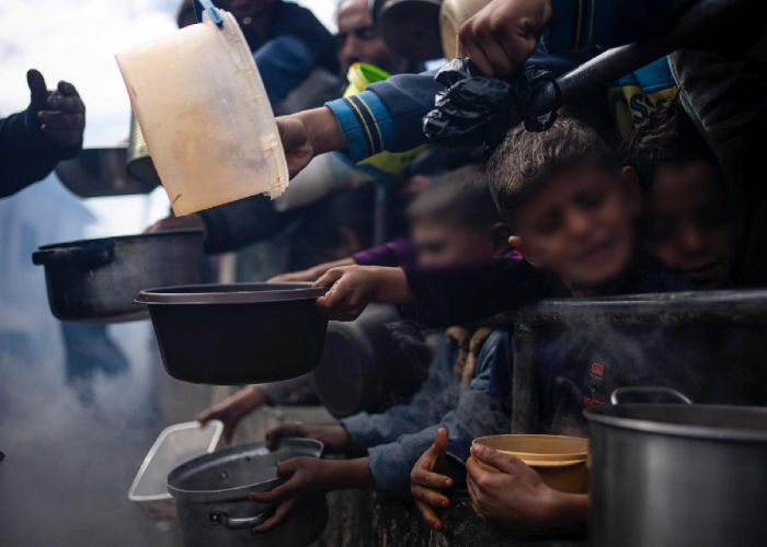 Niños palestinos formados para obtener comida durante la guerra entre Israel y Hamás.