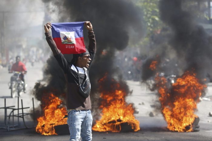 Un manifestante con una bandera haitiana.