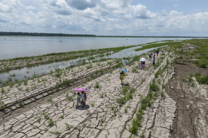 Varias personas caminando por una parte del río Amazonas.