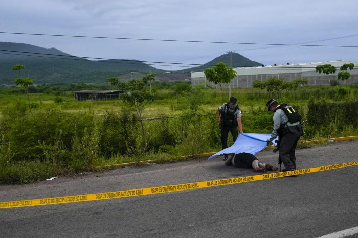 Agentes de la Guardia Nacional mexicana cubren un cadáver encontrado a un lado de la carretera en Culiacán.