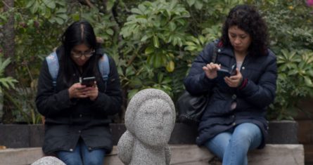 Dos mujeres utilizan su teléfono celular en calles de la Ciudad de México.