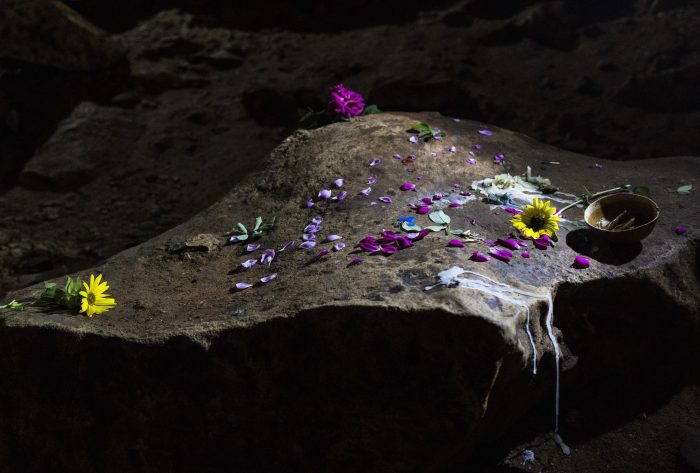 Velas y flores en un cenote tras ofrenda maya